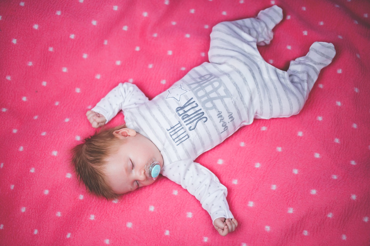 Baby schläft auf rosa Kuscheldecke